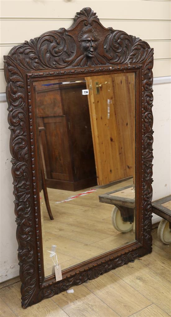 A carved oak mirror W. 85cm
